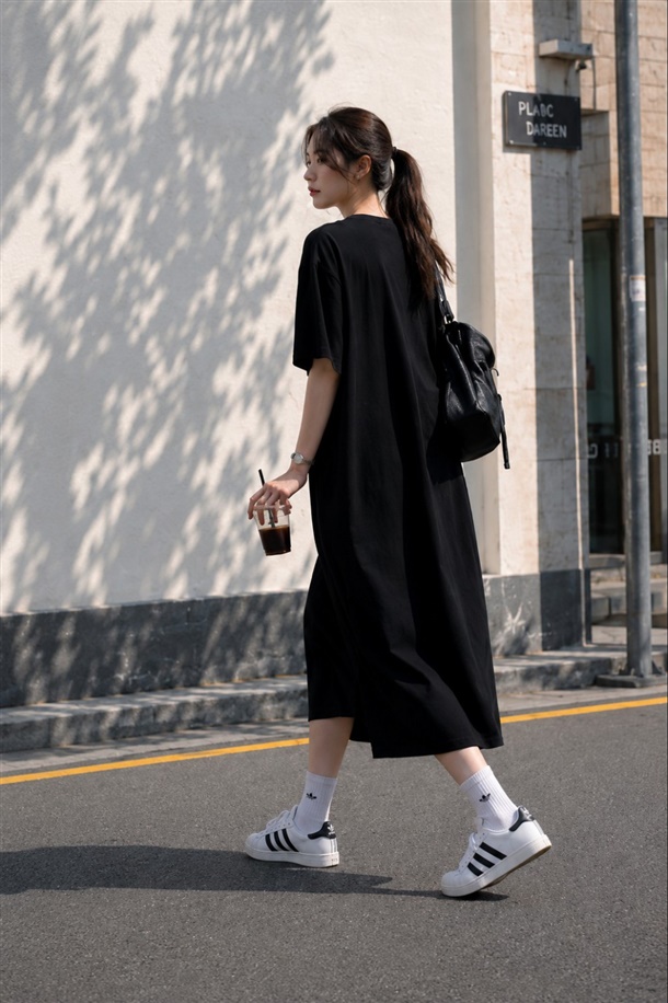 Woman in a casual t-shirt dress with white sneakers